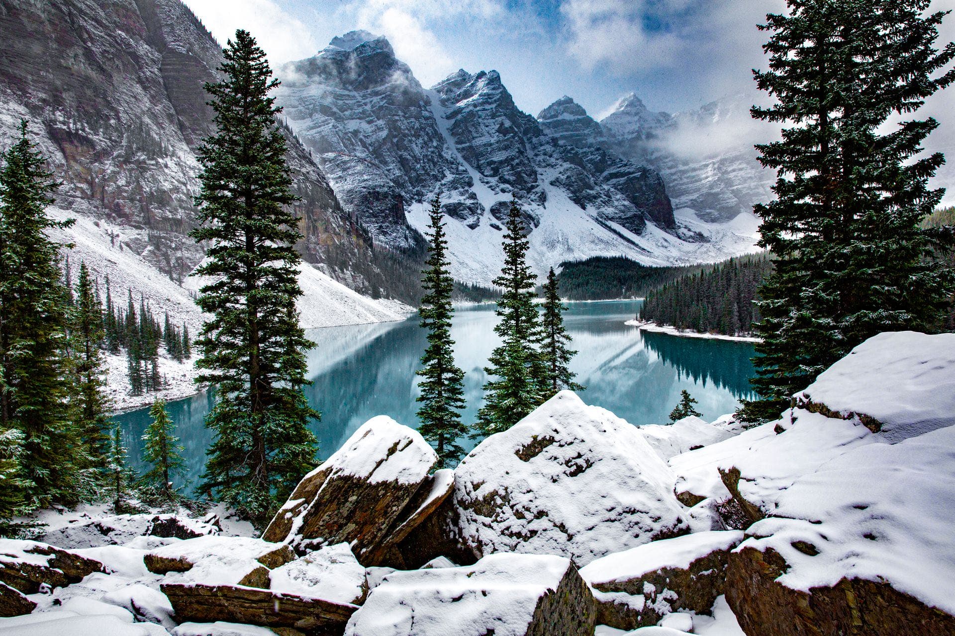 A turquoise glacial lake ringed by snow-covered mountains, evoking Nordic cold-water culture